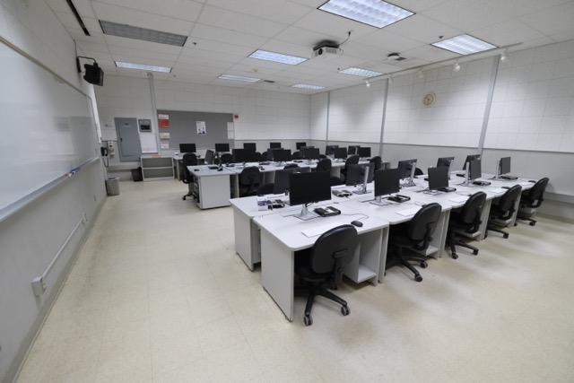 Empty computer lab with rows of monitors and swivel chairs (photograph)