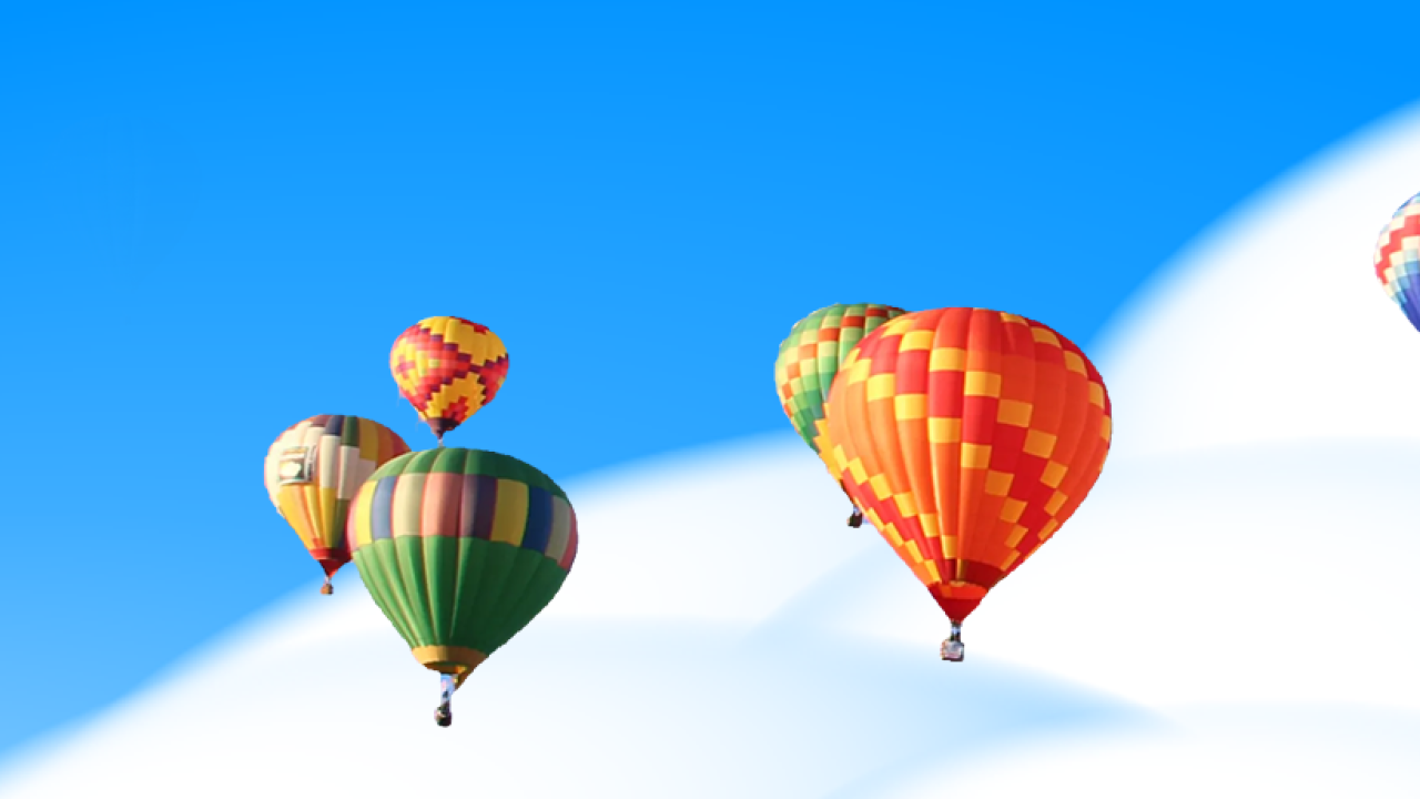 hot air balloons above clouds in sky